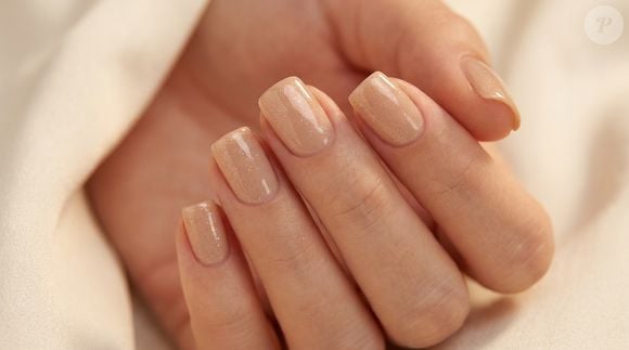 Base nude e camada fina de glitter dourado: a combinação transforma o clássico em opção festiva sem perder a elegância do neutro