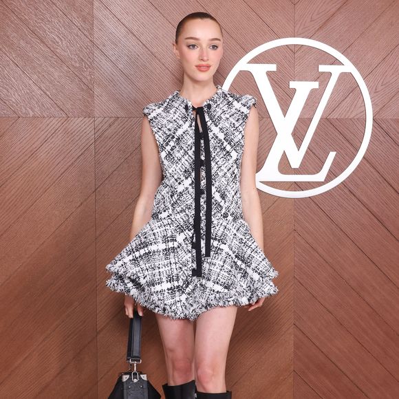 A atriz Phoebe Dynevor usando uma bota preta e vestido super diferente durante a Paris Fashion Week 2025.