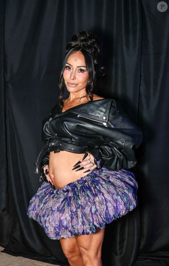 Sabrina Sato chamou atenção ao prestigiar um evento de moda em São Paulo com a barriga de gravidez à mostra. A apresentadora apostou em uma jaqueta cropped de couro preta, com mangas volumosas, zíperes e fivelas, combinada a uma minissaia balonê estampada em tons de roxo, azul e verde