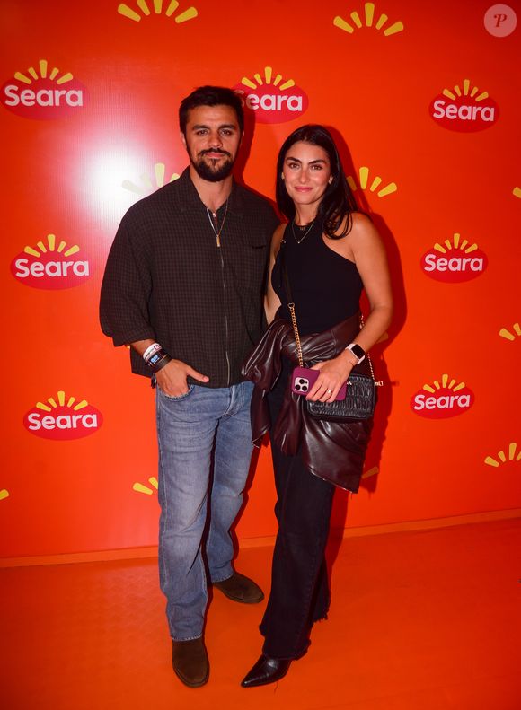 Felipe Simas apostou em uma camisa xadrez escura, jeans e botas, enquanto Mariana Uhlmann escolheu um look preto com blusa de um ombro só, calça comfy e jaqueta de couro