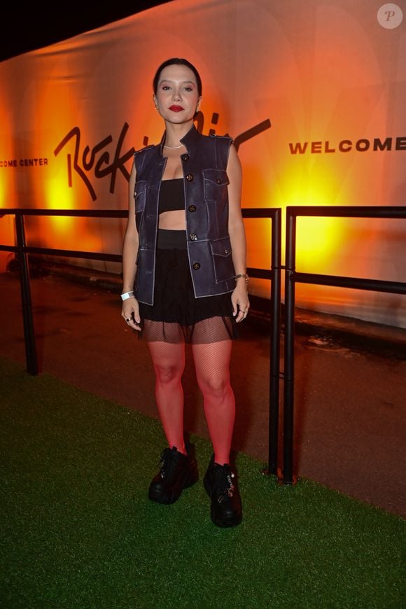 Lorena Comparato escolheu um look com colete de couro, top preto, minissaia, meia-calça arrastão e tênis chunky