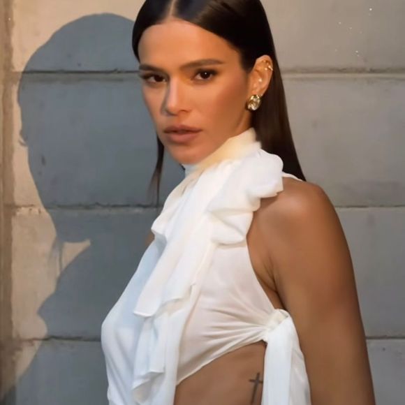Para completar a produção, Bruna Marquezine investiu em um penteado extremamente polido, com os fios lisos e alinhados, repartidos ao meio, criando um efeito espelhado que destaca a estrutura do rosto e adiciona um toque de sofisticação ao visual.