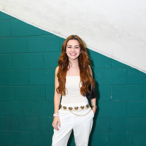 Klara Castanho apostou em um look monocromático ao combinar um top tomara-que-caia branco com calça de alfaiataria reta. O destaque da produção ficou por conta do cinto de correntes e pingentes de corações dourados marcando a cintura