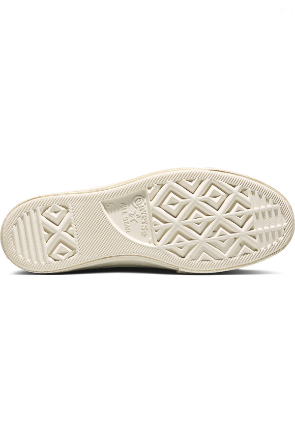 Inspirado na atualização da linha Chuck 70, o tênis traz um solado mais alto com acabamento envernizado brilhante, detalhe que reforça a proposta retrô do modelo