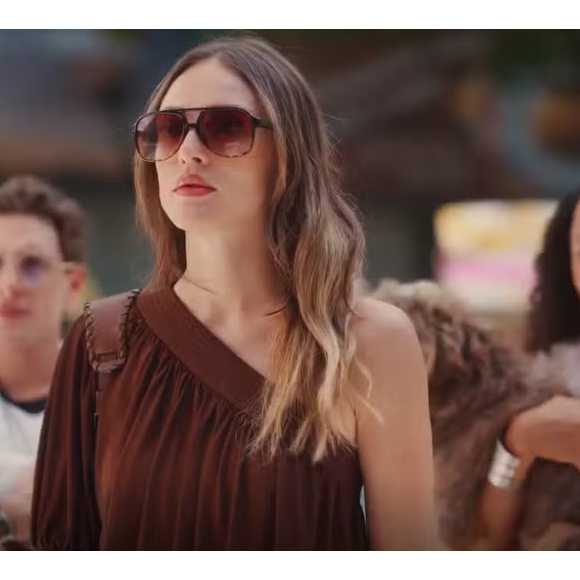 Outro destaque do guarda-roupa da personagem é o conjunto monocromático marrom chocolate assinado por Reinaldo Lourenço. A produção, que combina uma blusa de um ombro só com saia curta balonê avaliada em R$ 1.697,00, traduz o conceito de elegância sem esforço