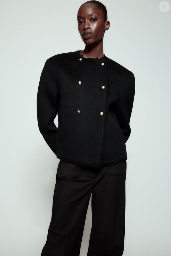 Segundo a descrição da Zara, o casaco preto da ZW Collection é confeccionado em tecido com mistura de lã e apresenta gola redonda, mangas amplas e bolsos frontais