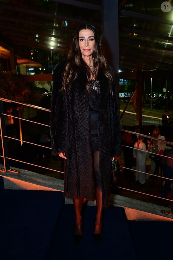 Mônica Martelli: a atriz apostou em um look que combina elegância noturna e texturas de inverno. Ela veste um casaco longo encorpado em tom escuro, com textura chevron felpuda, usado sobre um vestido preto com detalhes em renda e transparência no decote e na barra. Finalizando o visual, utiliza meia-calça preta translúcida, scarpins pretos de bico fino e uma bolsa de mão em tom escuro