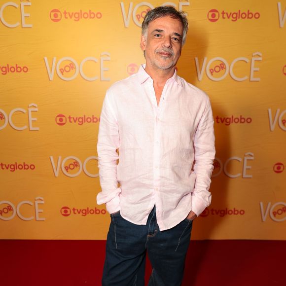 Ângelo Antônio investe em um estilo casual chique ao combinar camisa de linho rosa-claro levemente desabotoada e calça jeans reta em lavagem escura. Nos pés, tênis de cano baixo e solado robusto na cor branca arrematam a proposta descontraída