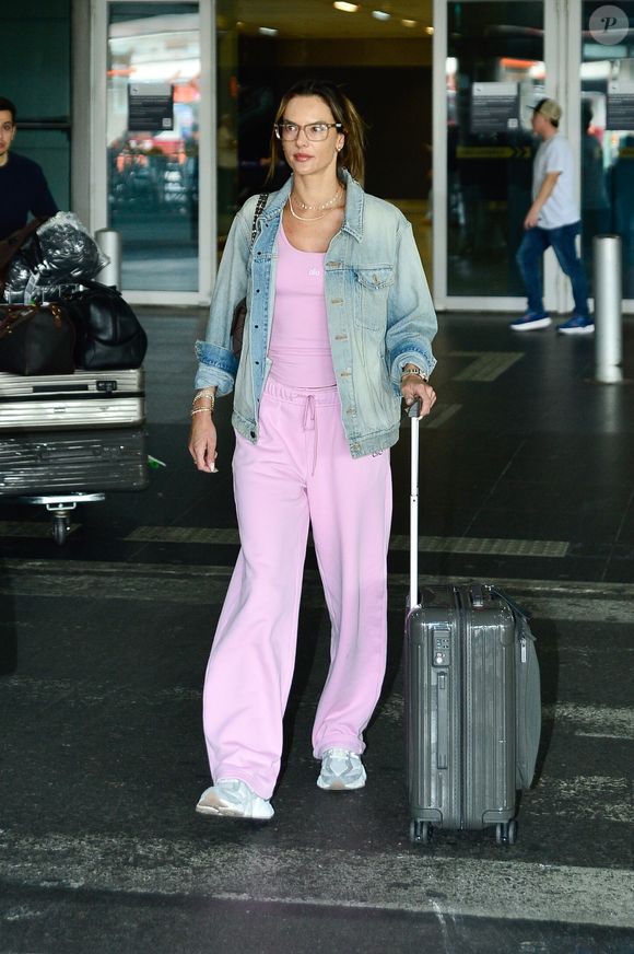 Alessandra Ambrosio escolheu um conjunto rosa claro de blusa justa e calça de moletom de cintura alta com cordão