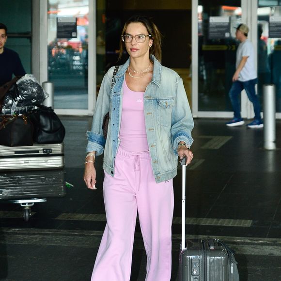 Alessandra Ambrosio escolheu um conjunto rosa claro de blusa justa e calça de moletom de cintura alta com cordão