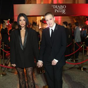 Natália Rosa e Marcella Rica: o casal apresentou propostas distintas de ternos modernos. Natália usou um blazer preto alongado com lapelas de cetim (estilo smoking) sobre calças de renda preta transparente com modelagem flare, unindo a alfaiataria masculina à delicadeza feminina. Já Rica optou por um terno completo de corte impecável, com colete, camisa branca e gravata slim preta, mantendo uma estética andrógina clássica e extremamente elegante
