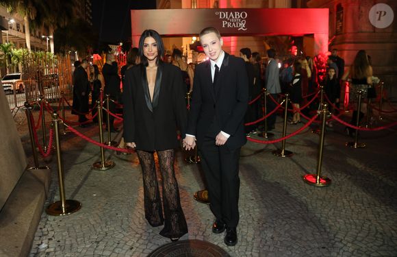 Natália Rosa e Marcella Rica: o casal apresentou propostas distintas de ternos modernos. Natália usou um blazer preto alongado com lapelas de cetim (estilo smoking) sobre calças de renda preta transparente com modelagem flare, unindo a alfaiataria masculina à delicadeza feminina. Já Rica optou por um terno completo de corte impecável, com colete, camisa branca e gravata slim preta, mantendo uma estética andrógina clássica e extremamente elegante