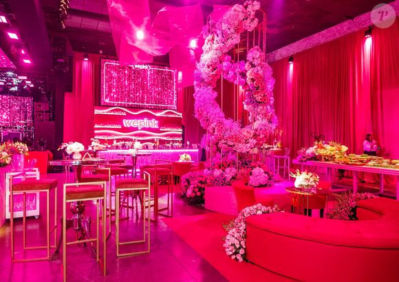 Poltronas rosa-chiclete, mesas douradas e flores formam um dos lounges da festa da WePink