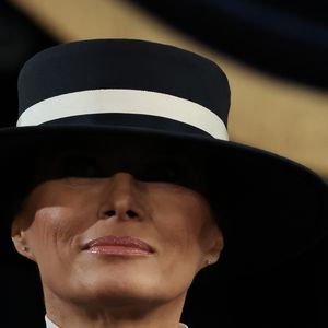 Na cabeça, Melania usou um chapéu azul-marinho com uma parte branca.