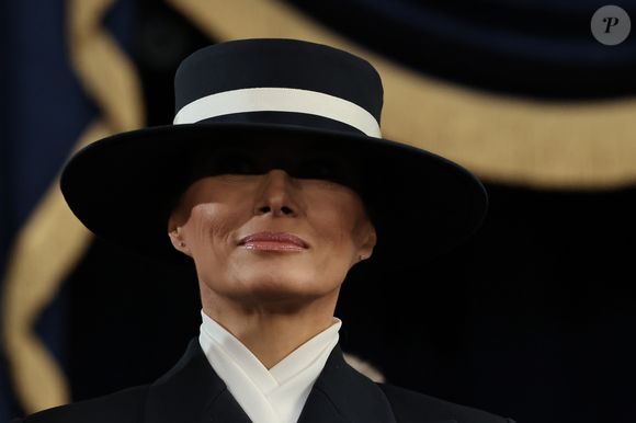 Na cabeça, Melania usou um chapéu azul-marinho com uma parte branca.