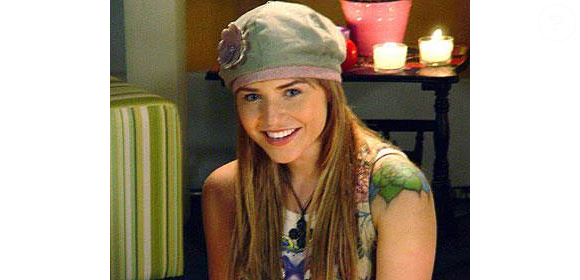 Letícia Colin em 'Floribella': o corte é um médio para longo bem repicado, com camadas graduais e pontas desfiadas para volume. O grande detalhe é o estilo balayage ou luzes de contorno (money piece) em um tom loiro dourado mais claro na frente e nas pontas, contrastando com o fundo castanho. A boina cobre a parte superior