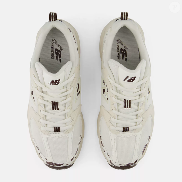 O cabedal em mesh dos New Balance 530 contribui para a respirabilidade, enquanto as sobreposições ajudam a construir o visual característico da linha, reunindo detalhes funcionais e uma estética que permite explorar diferentes combinações de roupas