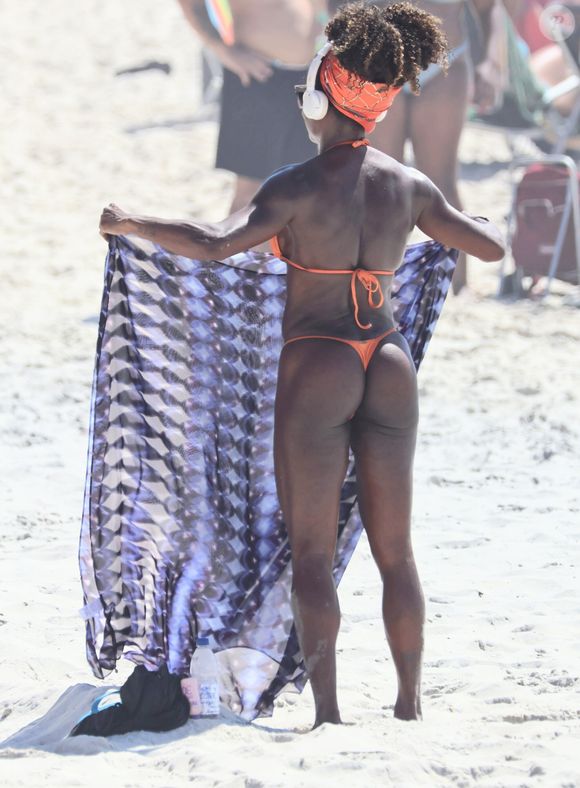 Adriana Bombom usou um biquíni fio-dental micro para se bronzear na praia