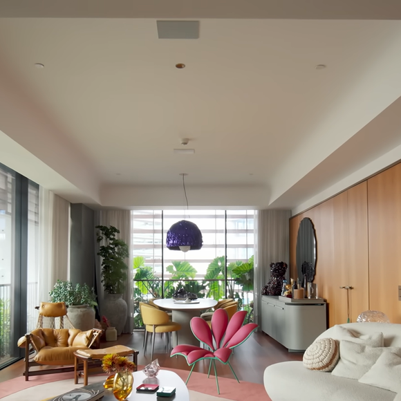 A decoração do apartamento foi desenvolvida pela arquiteta Ilana Santiago, que combinou uma base neutra com elementos vibrantes inspirados no feng shui e em peças de arte escolhidas pelo casal
