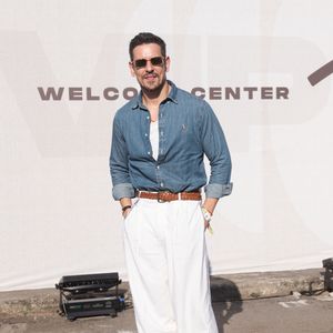 João Vicente de Castro: sua aposta é uma camisaria em jeans de lavagem média com mangas dobradas sobre regata branca, combinada com calça alfaiatada ampla off-white de cintura alta. O toque final vem com cinto trançado de couro marrom, mocassins em camurça escura e óculos escuros retangulares com armação metálica