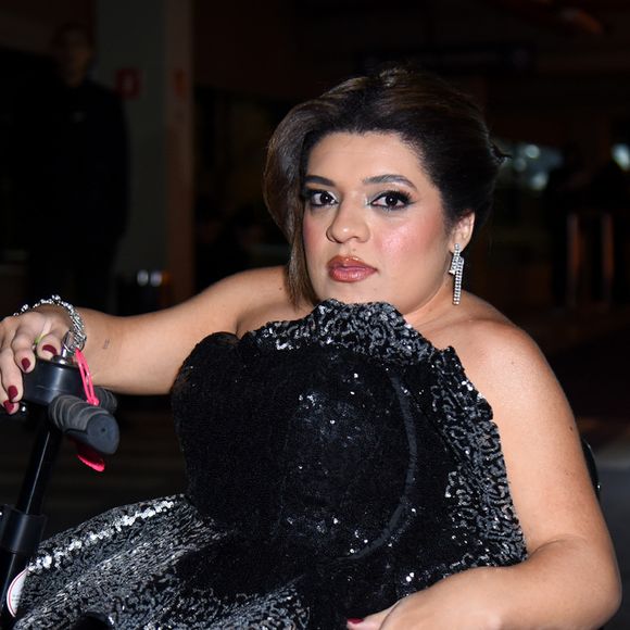 Pequena Lo apostou em um vestido estruturado tomara que caia com camadas prateadas e paetês pretos, trazendo brilho e volume dramático ao visual