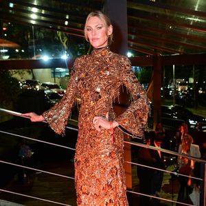 Shirley Mallmann: a top model optou por um vestido longo de gola alta e mangas longas estilo boca de sino, inteiramente bordado com paetês, vidrilhos e texturas metálicas em tom bronze/cobre. A produção conta com detalhes de franjas reluzentes e é finalizada com os cabelos presos em um coque alinhado