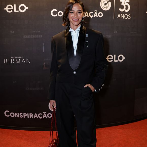 O styling de Bruna Marquezine ganha frescor com sapatos bicolores e uma bolsa pequena em tom vinho, criando um contraste pontual que eleva a produção. Recém-chegada de Oscar 2026, ela mostrou que o mood red carpet internacional segue firme!