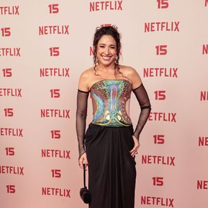 Gisele Ittié: aposta em um corset tomara-que-caia ilustrado com estampa artística de tons azulados e terra, combinado com saia longa preta drapeada na cintura, luvas de tule pretas e bolsa de mão estruturada