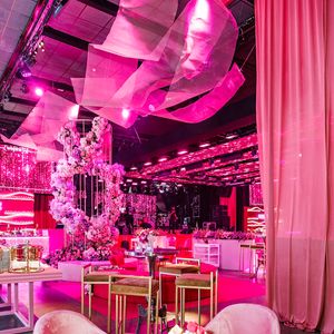 Poltronas de veludo rosa e mesas douradas compõem uma das áreas de lounge da comemoração da WePink