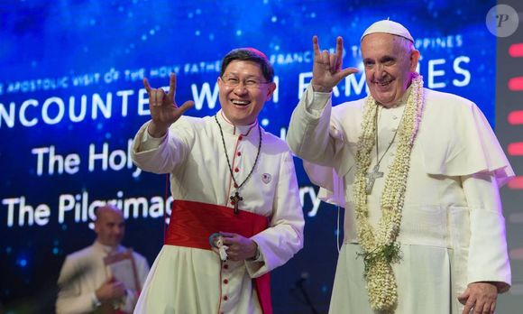 O Papa Francisco e o acerbispo de Manila, Luis Antonio Tagle, cumprimentam público com gesto popular