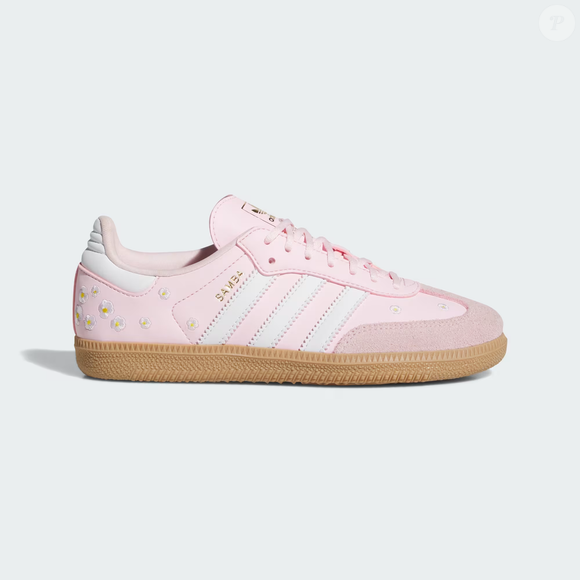 O clássico Adidas Samba ganha uma versão romântica com flores bordadas no cabedal, combinando referências esportivas e detalhes delicados. Segundo a descrição disponível no site oficial da Adidas Brasil, o modelo preserva características tradicionais, como a biqueira em T e o solado de borracha. O preço informado é de R$ 799,99
