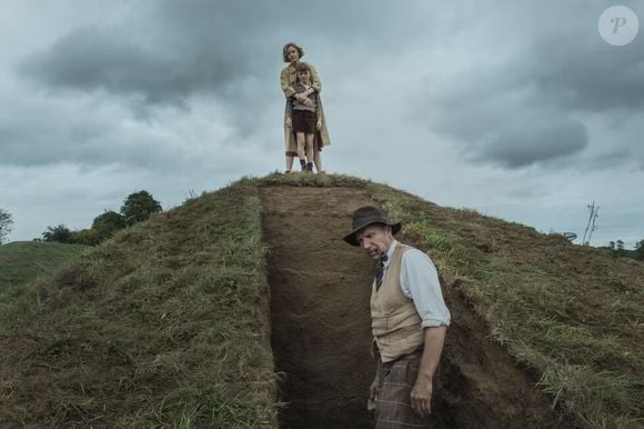 Para isso, ela contrata Basil Brown (Ralph Fiennes), um arqueólogo autodidata, mas acaba se envolvendo com ele