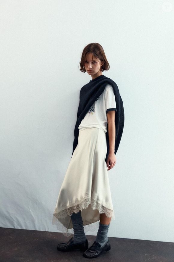 Os vestidos slip dress seguem em alta, principalmente com rendas delicadas e tecidos suaves, e as saias acetinadas entram na mesma tendência romântica. A Zara aposta em um modelo branco com acabamento assimétrico e acetinado que traduz perfeitamente essa estética sofisticada e feminina com renda. Valor: R$ 229,00.