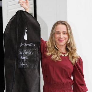 Estilista Lethicia Bronstein foi vista ao chegar no casamento de Ana Maria Braga com o vestido de noiva na mão