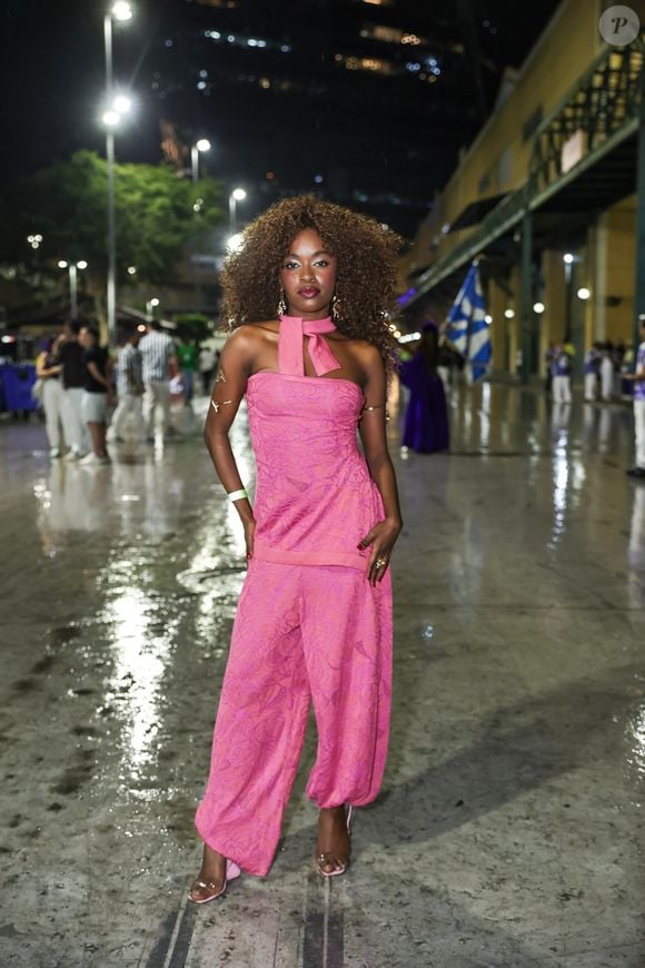 Nicolle Fernandes surgiu com um conjunto monocromático cor-de-rosa composto por blusa tomara que caia ajustada e detalhe de faixa amarrada ao pescoço como chocker, combinada a uma calça pantalona de modelagem solta com textura trabalhada. Nos pés, optou por sandálias de salto em tom rosa claro com tiras transparentes, além de braceletes dourados e brincos combinando