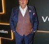 O renomado chef e jurado de TV Érick Jacquin mantém sua assinatura de elegância clássica francesa com um toque de personalidade. Ele comparece ao evento vestindo um terno de três peças composto por um paletó e calça em tecido azul-safira vibrante, contrastado por um colete social abotoado em tom de marrom-rosado acinzentado. Por baixo, uma camisa social branca de colarinho aberto sem gravata mantém o visual imponente porém confortável. Fiel aos detalhes, Jacquin adorna a lapela com um broche floral prateado com pérolas e insere um lenço de bolso rosa-antigo, completando o visual com sapatos sociais oxford pretos de couro legítimo