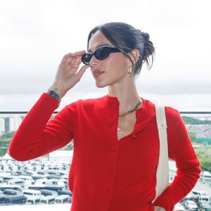 Bruna Marquezine usou penteado preso em coque baixo e óculos escuros de armação oval e acessórios dourados sutis completaram o visual