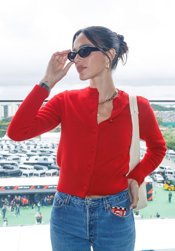 Bruna Marquezine usou penteado preso em coque baixo e óculos escuros de armação oval e acessórios dourados sutis completaram o visual