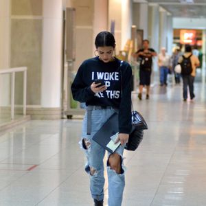 Bruna Marquezine em aerolook com botas: atriz apostou um moletom com a frase 'I Woke Up Like This', trecho da música 'Flawless', de Beyoncé, com calça destroyed, bota de cano médio e bolsa Saint Laurent de R$ 8 mil