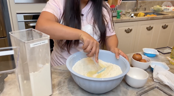 Com a massa pronta, acrescente a farinha de trigo e o fermento e incorpore bem