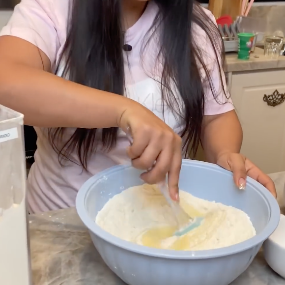 Com a massa pronta, acrescente a farinha de trigo e o fermento e incorpore bem