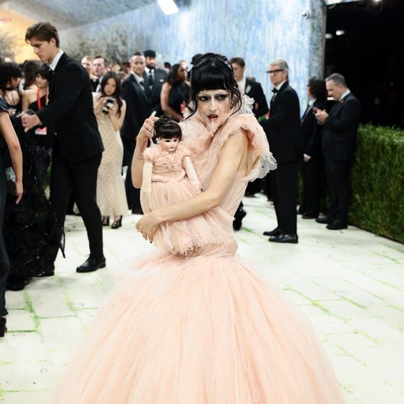 María Zardoya impactou o tapete vermelho com uma estética 'porcelana sombria', vestindo um suntuoso vestido de baile em tule pêssego com camadas volumosas. O elemento disruptivo ficou por conta da boneca idêntica que carregava, mimetizando seu próprio visual, além de uma maquiagem artística com sobrancelhas desestruturadas e um véu de tule que cobria parte de seu rosto