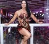 Viviane Araújo posou sorridente na quadra do Salgueiro com um look carnavalesco de pedrarias vermelhas, pretas e douradas. A produção combinou transparência, franjas e aplicações brilhantes para uma noite de samba no Rio