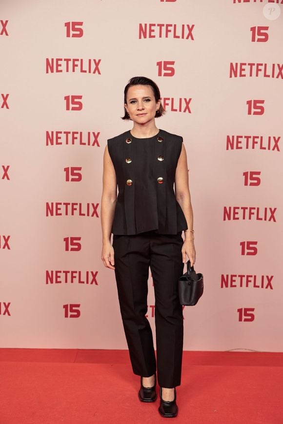 Bianca Comparato: escolheu um conjunto alfaiataria preto composto por um colete sem mangas estruturado com peplum curto e botões dourados duplos, combinado com calça reta, sapato preto e uma bolsa de mão estruturada