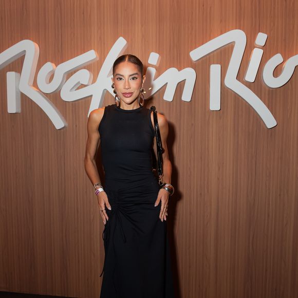 Renata Saldanha aposta em uma produção minimalista com inspiração sophisticated rocker. A criadora de conteúdo veste um vestido midi preto ajustado ao corpo com franzido lateral na cintura, combinando com botas de bico fino e salto em tom escuro, bolsa de ombro em couro envernizado e imponentes brincos de argola metálicos
