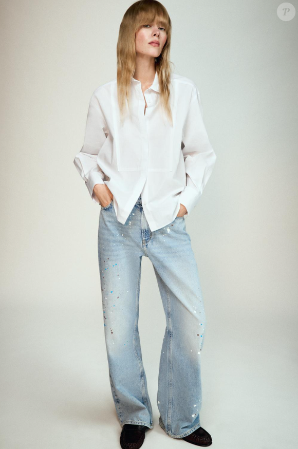 Camisa branca da Zara é levemente alongada, tem gola na lapela, mangas longas, além de fechamento frontal com botões