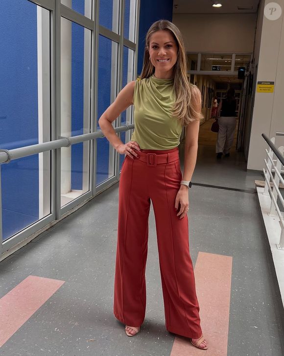 Moda de Jacqueline Brazil no 'Jornal Hoje': Jornalista da Globo usa calça social na cor telha e blusa sem mangas verde.