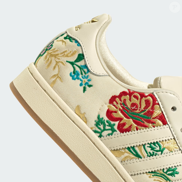 Entre os lançamentos mais delicados da temporada, o novo Adidas Superstar II chama atenção pelo visual elegante e pelos desenhos florais costurados no couro. O modelo reforça a tendência dos tênis que unem conforto e informação de moda