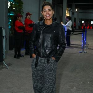 Lucy Alves: veste jaqueta biker de couro preta, camiseta escura, calça ampla em animal print de leopardo em tons cinzas e botas pretas