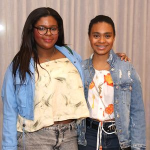 Laura e Maria estavam vestindo calças jeans, blusas estampadas, jaquetas e tênis - um estilo confortável, jovem e descolado para o show